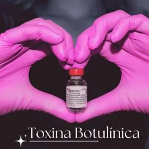 Frasco de toxina botulínica sostenido por guantes rosas en forma de corazón, simbolizando estética y cuidado facial en Santiago Centro